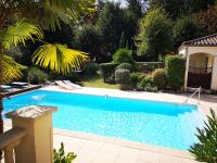 a large blue swimming pool in a yard at Le Mas des Geais in Atur