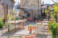 een buitenterras met tafels, stoelen en een parasol bij Casa Aquadulza in Tremezzo