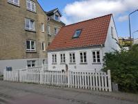 a white house with a white fence and a red roof at Aalborg City Rooms ApS in Aalborg