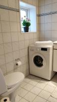a bathroom with a washing machine and a toilet at Aalborg City Rooms ApS in Aalborg