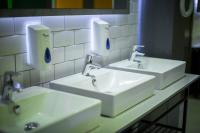 a bathroom with two sinks and two soap dispensers at Kick Ass Greyfriars (18+) in Edinburgh