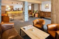 a waiting room with leather chairs and a table at Carlina in La Clusaz