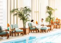 two people sitting in chairs next to a pool at The Peninsula Chicago in Chicago