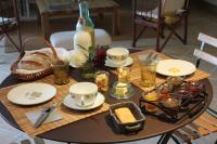 a table with plates and a basket of bread and drinks at Le Clos des Pierres Dorées in Theizé