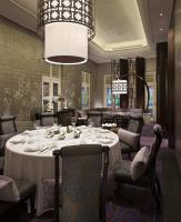 a dining room with a table and chairs and a chandelier at Capella Singapore in Singapore
