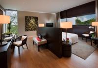 a hotel room with a bed and a desk at Capella Singapore in Singapore