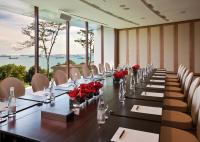 a long table with red roses in a room with windows at Capella Singapore in Singapore