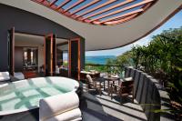 a patio with a hot tub and a table and chairs at Capella Singapore in Singapore
