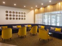 a waiting room with yellow chairs and a blue couch at Lutecia Smart Design Hotel in Lisbon