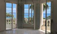 a room with doors open to a view of the ocean at Magnifique Appartement Vue Mer in Vallauris