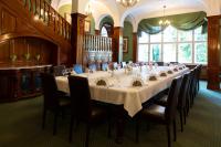 een grote eetkamer met een lange tafel en stoelen bij Schlosshotel Villa Westerberge in Aschersleben