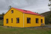 un edificio amarillo con techo rojo en Lækjarhus Farm Holidays, en Borgarhöfn