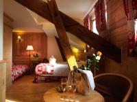 a room with a bed and a table with wine glasses at Auberge du Manoir in Chamonix