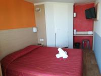 a bedroom with a red bed with a white teddy bear on it at Premiere Classe Cambrai Proville in Cambrai