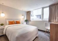a bedroom with a large white bed with orange pillows at Via Loft Hotel in Taipei