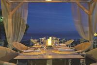 a table with wine glasses on it with the ocean in the background at Galaxy Beach Resort BW Premier Collection in Laganas