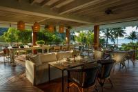 a restaurant with tables and chairs with a view of the ocean at Rosewood Phuket in Patong Beach