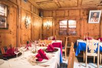 a dining room with tables and chairs with red napkins at Hotel Chalet Alpenrose Bio Wellness Naturaktivhotel in Cogolo