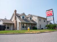 una boca de incendios amarilla frente a una casa en The Ranchland Inn Kamloops, en Kamloops