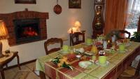 a dining room table with a fireplace and a table set with green dishes at Chambres d&#39;hôtes La Hulotte 69 in Villechenève
