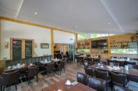 un ristorante con tavoli, sedie e lavagna di Usedom Bike Hotel & Suites a Ostseebad Karlshagen