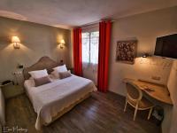 a bedroom with a bed and a desk with a computer at The Originals Boutique, Hôtel du Parc, Cavaillon (Inter-Hotel) in Cavaillon