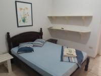 a bedroom with a bed with blue pillows on it at Hotel Nils in Itapoa