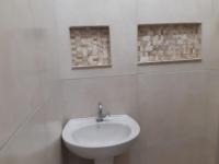 a white bathroom with a sink and two windows at Hotel Nils in Itapoa