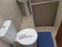 a bathroom with a white toilet and a blue rug at Hotel Nils in Itapoa