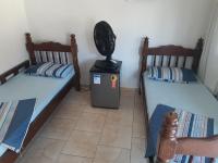 a room with two twin beds and a fan at Hotel Nils in Itapoa