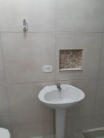 a white bathroom with a sink and a shower at Hotel Nils in Itapoa