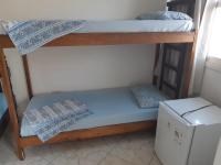 a bunk bed in a small room with a refrigerator at Hotel Nils in Itapoa