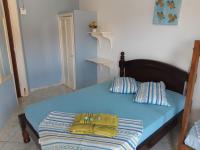 a blue bed with two pillows and a bag on it at Hotel Nils in Itapoa