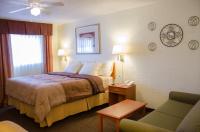 ein Hotelzimmer mit einem Bett und einem Stuhl in der Unterkunft Budget Inn &amp; Suites Colby in Colby