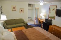 ein Schlafzimmer mit einem Bett und einer Couch und einem Fernseher in der Unterkunft Budget Inn &amp; Suites Colby in Colby