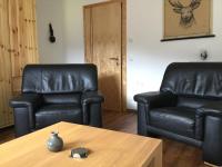 two leather chairs and a coffee table in a room at Almwirt in Bramberg am Wildkogel