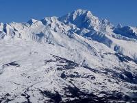a mountain covered in snow with mountains in the background at Plagne AIME 2000 Ski Apartments in Aime-La Plagne