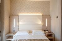 A bed or beds in a room at Hotel Capri Bardolino 3S