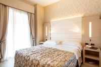 A bed or beds in a room at Hotel Capri Bardolino 3S