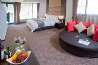a hotel room with a bed and a table with a bowl of fruit at Tai-Yi Red Maple Resort in Puli