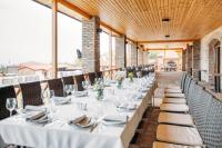 un comedor largo con mesas y sillas blancas en Schuchmann Wines Château,Villas & SPA, en Telavi