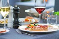 コンスタンツにあるHotel Schiff am Seeの料理の皿とワインのグラスが置かれたテーブル