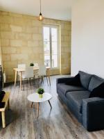 a living room with a couch and a table at Appartement De Lerme in Bordeaux