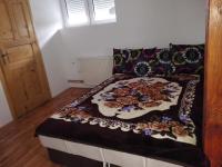 a bed with a blanket on top of it in a room at Pešić Apartmani in Kušići
