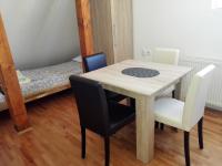 a table and chairs in a room with a bed at Pešić Apartmani in Kušići