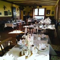 un comedor lleno de mesas con mesas blancas en Gasthaus Zur Burgschänke, en Aremberg