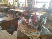 una mesa en un restaurante con mesas y sillas en Gasthaus Zur Burgschänke, en Aremberg