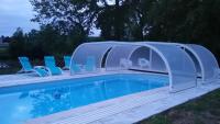 a swimming pool with a plastic cover over a swimming poolitures at Manoir des Turets in Yvré-lʼÉvêque