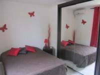 a bedroom with a mirror and a bed with red pillows at Mary Madinina in Fort-de-France