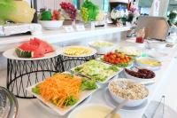 un buffet pieno di diversi tipi di cibo su piatti di Grand Hill Resort and Spa a Nakhon Sawan